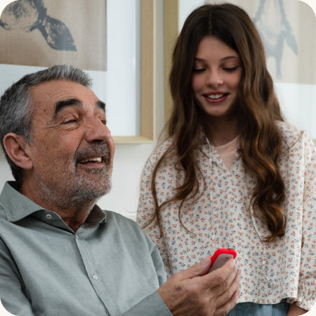 une fille et son grand-père qui tient un walkie perroquet rouge dans sa main