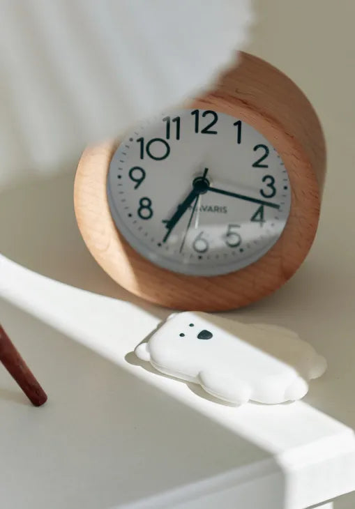 walkie ours sur une table a côté d'un réveil