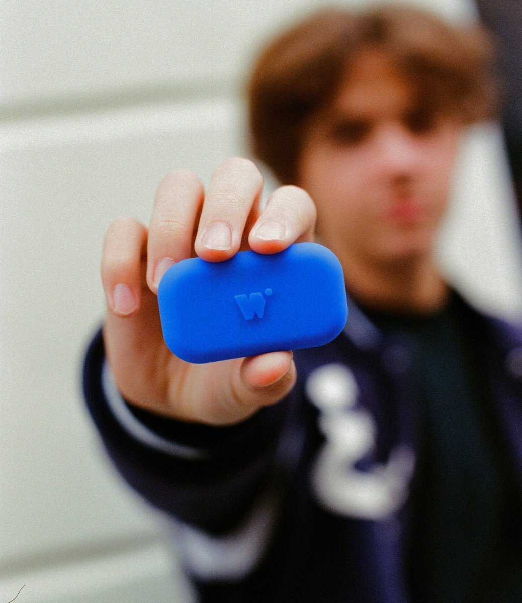un adolescent qui tend un Walkie bleu électrique vers la caméra