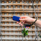 main qui tient un walkie bleu marine accroché à un porte-clés