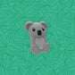 Walkie koala vu de côté sur un arrière plan représentant des bambous