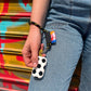 main qui tient un walkie foot accroché à un porte-clés