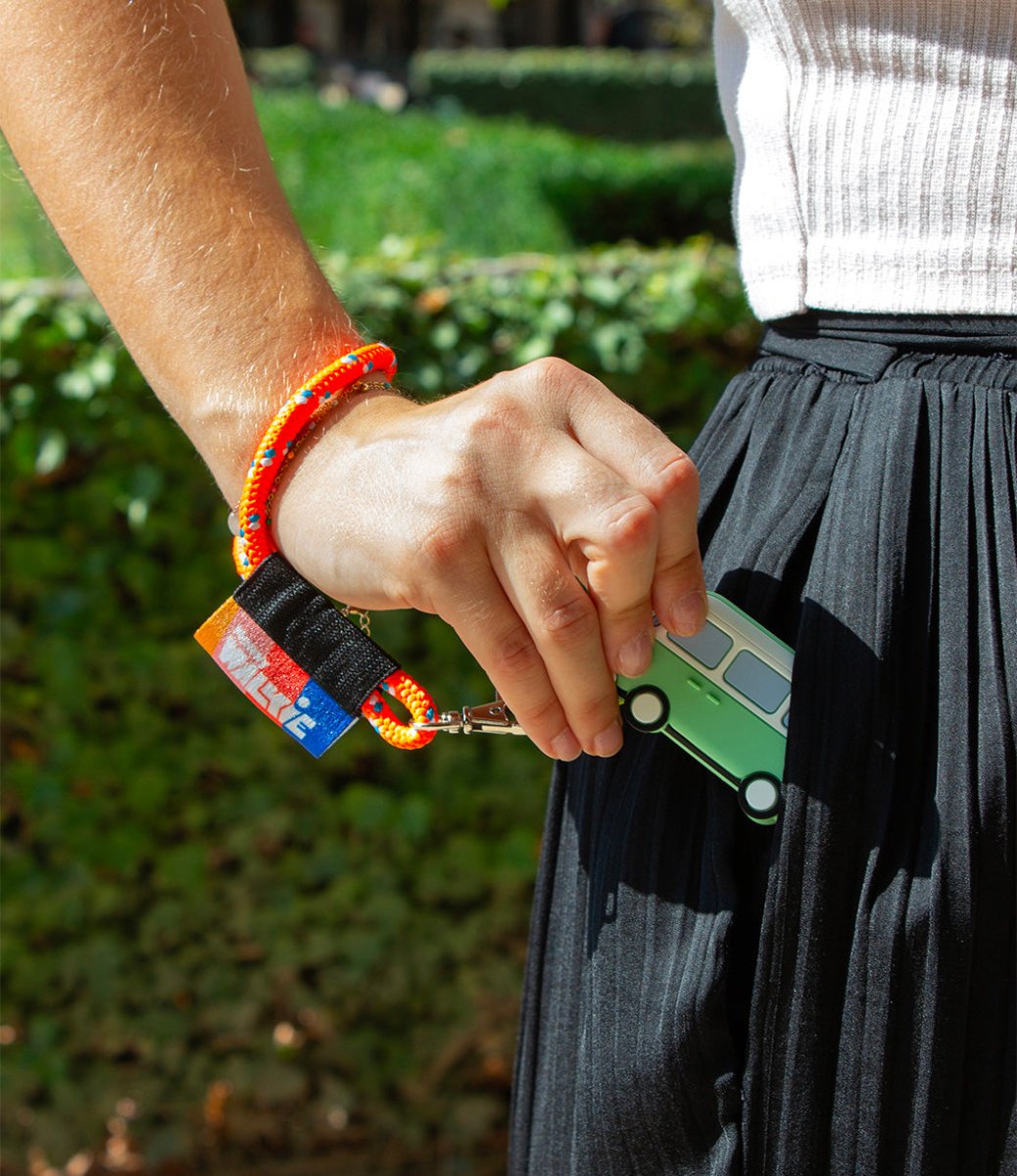 femme qui met un walkie van accroché à son porte-clés orange fluo dans sa poche